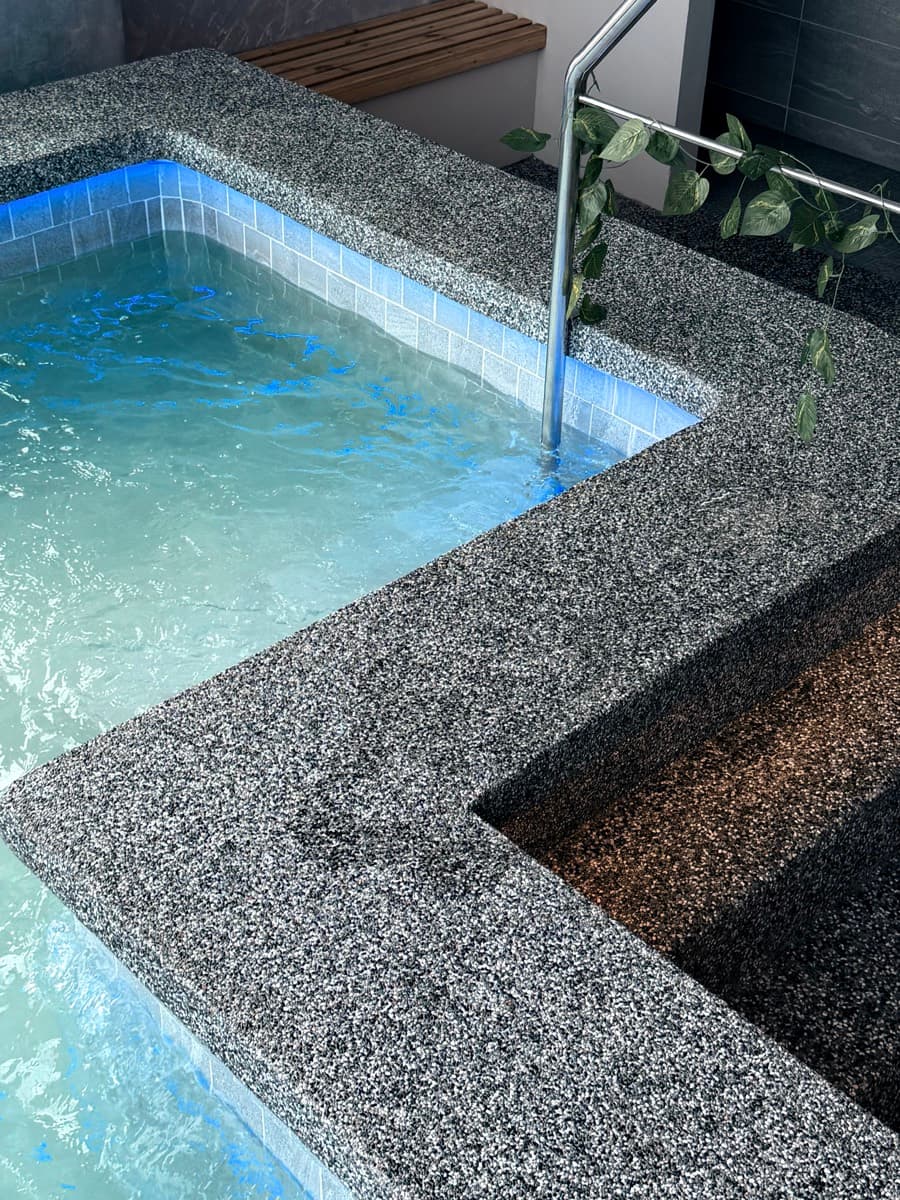 The cold plunge — blue water in a terrazzo surround