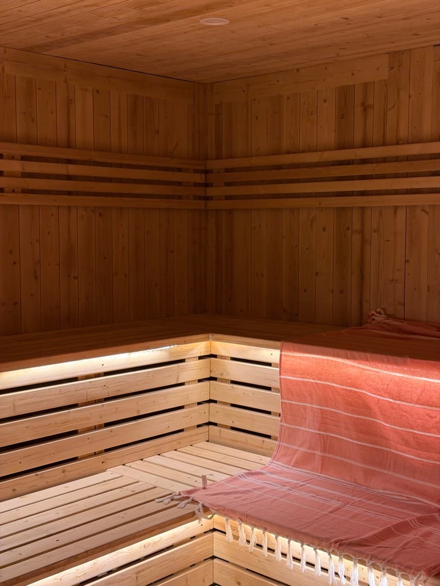 Inside the sauna, warm cedar and a linen throw